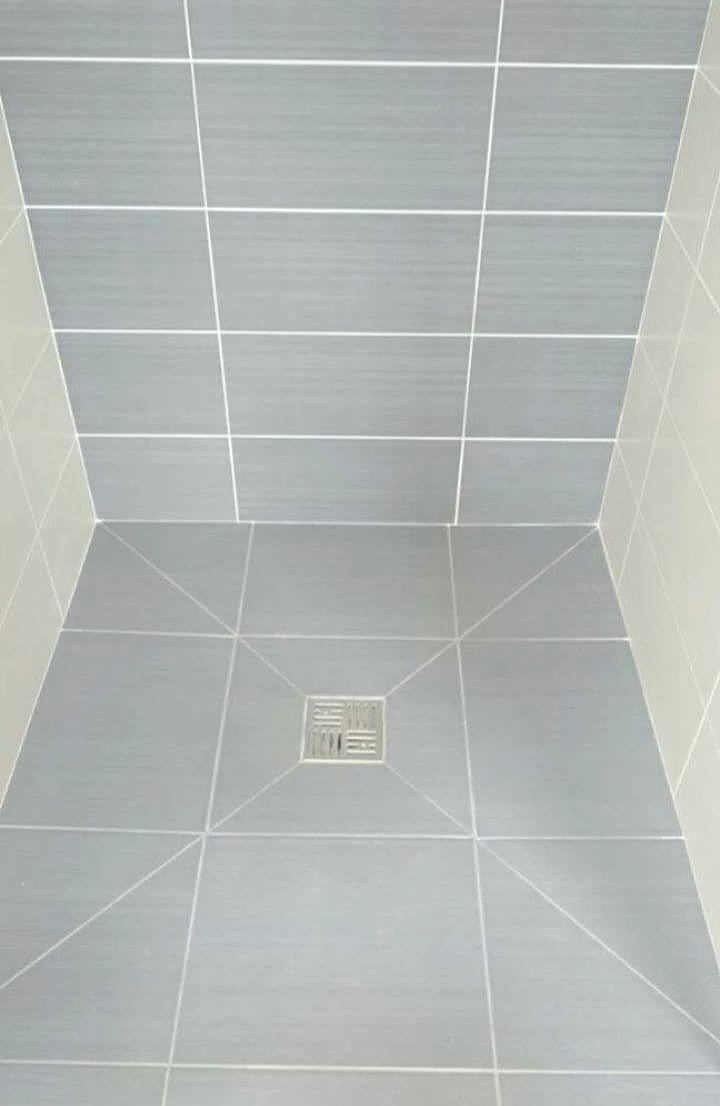 Shower floor regrouting with neat grout lines around the drain