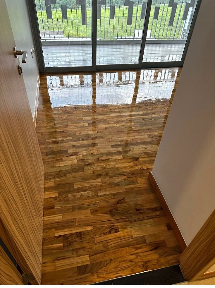 Wood floor polished near balcony doors with a glossy finish