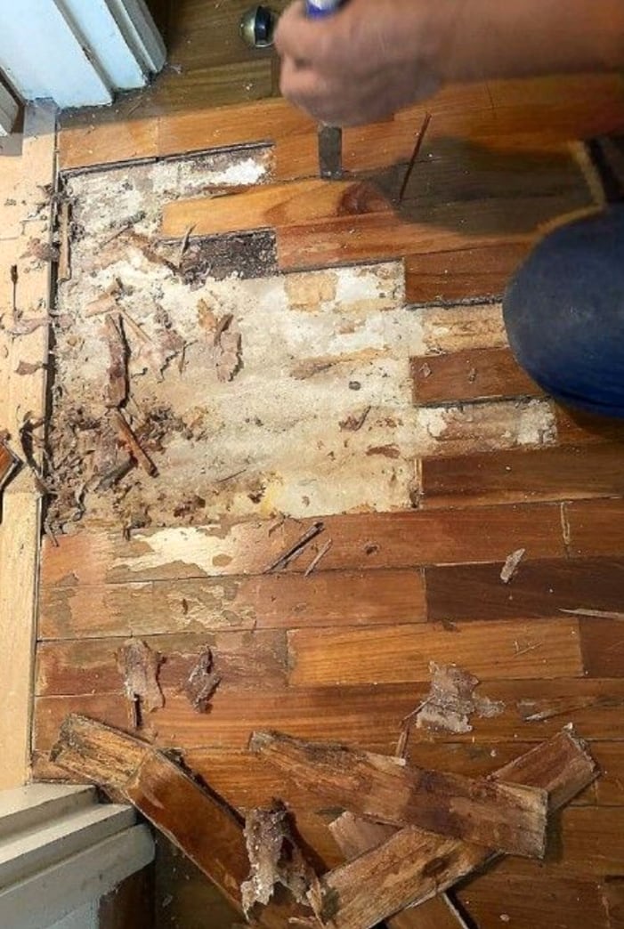 Damaged parquet area with old pieces removed for restoration