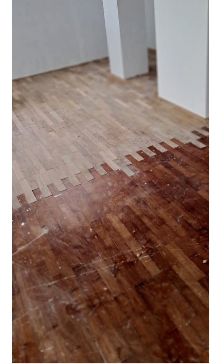 Old parquet varnish being removed during sanding preparation
