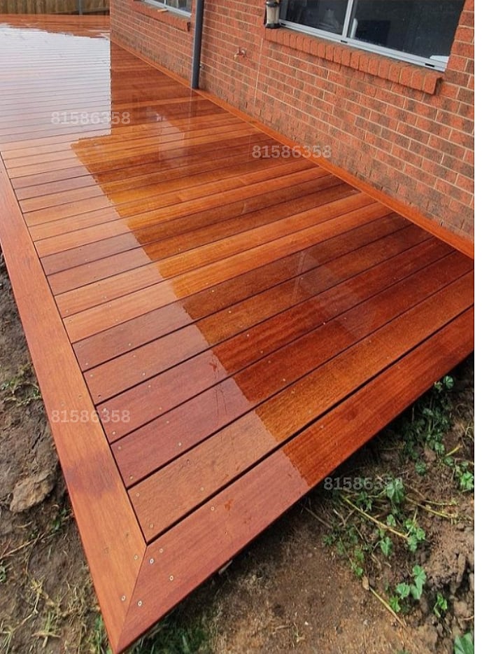 Outdoor timber deck receiving a glossy protective coating